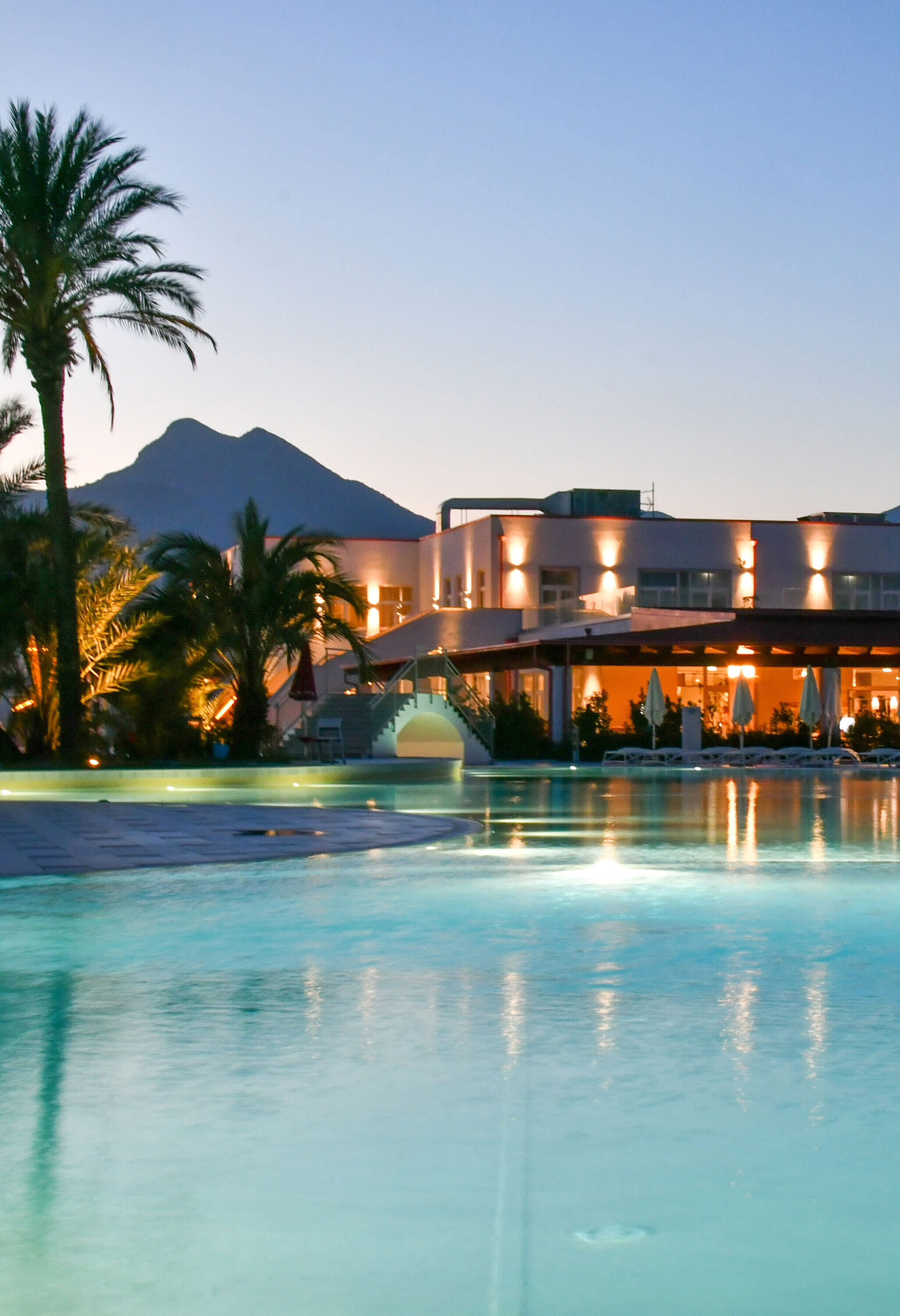 Pool Poolbeleuchtung am Abend im Maritim Resort Calabria mit Palmen und Gebirgskulisse