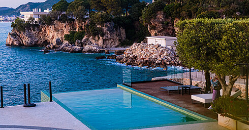 Pool Infinity-Pool im Maritim Resort Marina Bay mit Blick auf Felsküste, türkisfarbenes Meer und mediterrane Landschaft