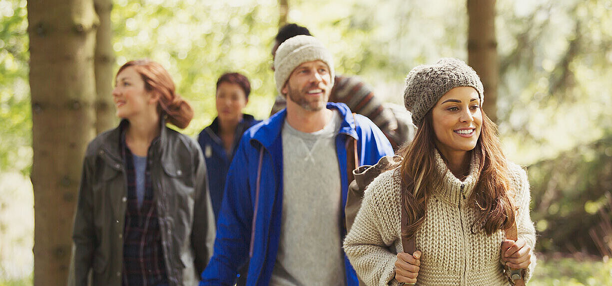 © KOTO - AdobeStock.com Gruppe von Freunden wandert im Wald und genießt die Natur