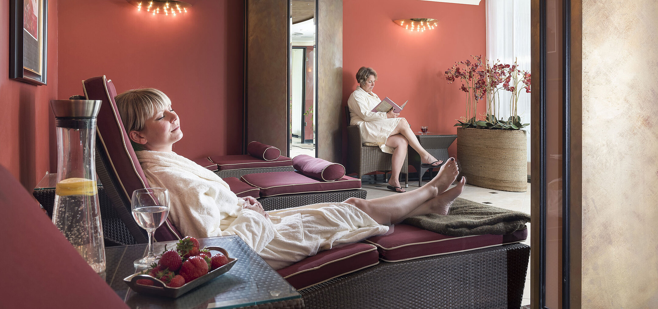 Ruhebereich Ruheraum mit roten Wänden im Maritim Seehotel Timmendorfer Strand, Gäste entspannen auf Liegen.